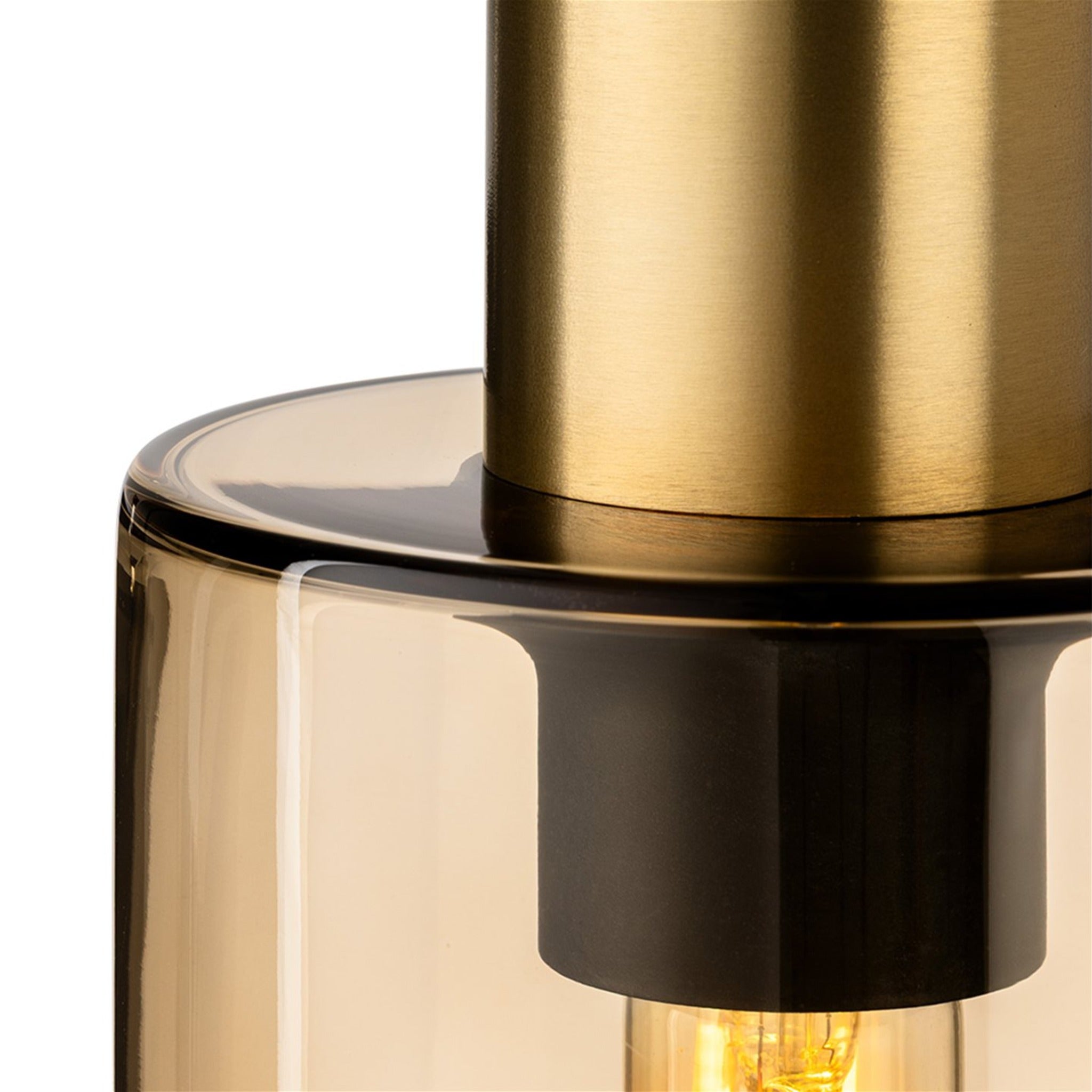 Close-up detail of the Arden pendant showing the satin brass stem meeting the smoked amber glass shade