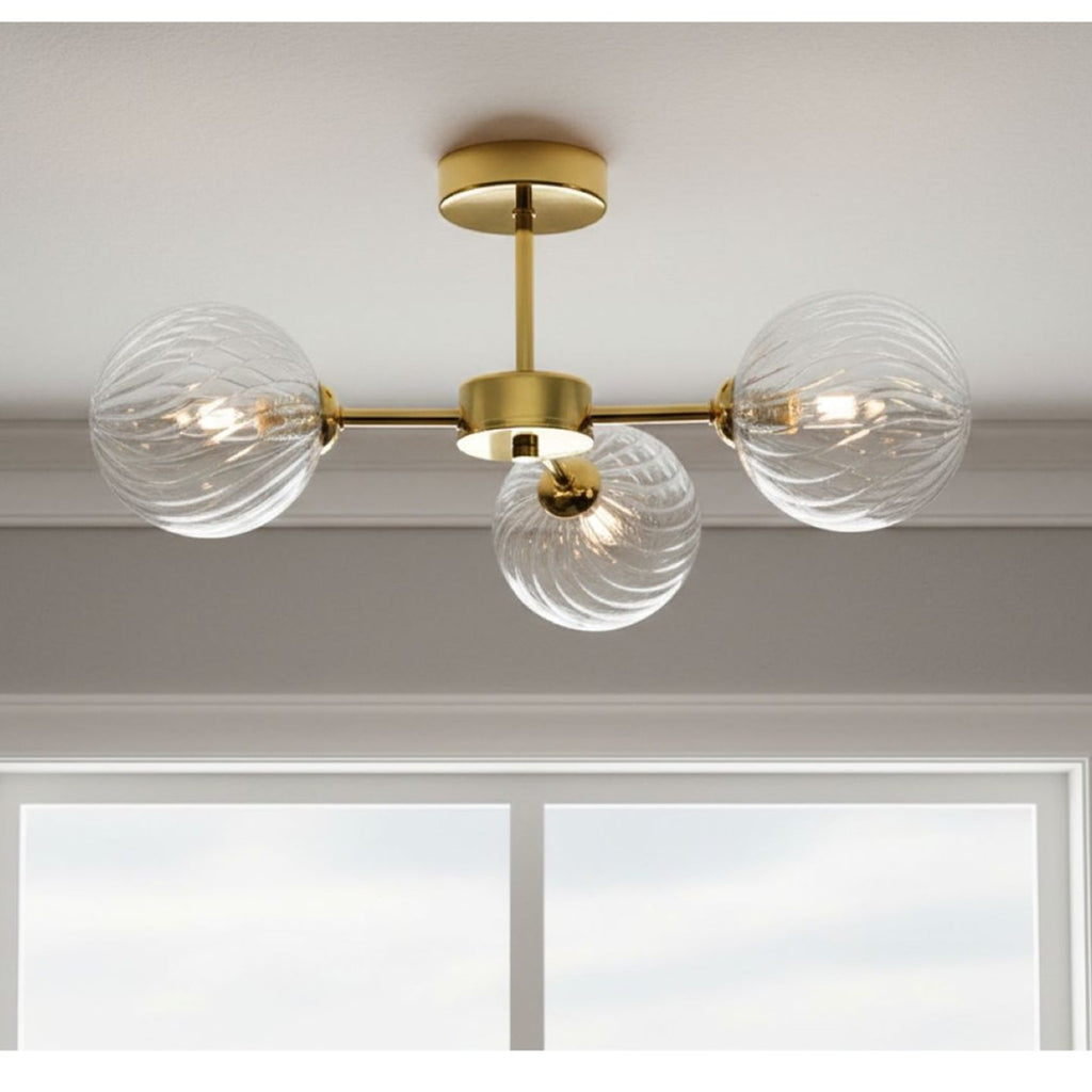 Ashby Swirled Glass 3 Light Semi-Flush Ceiling Light in brass, lit and fitted to a ceiling