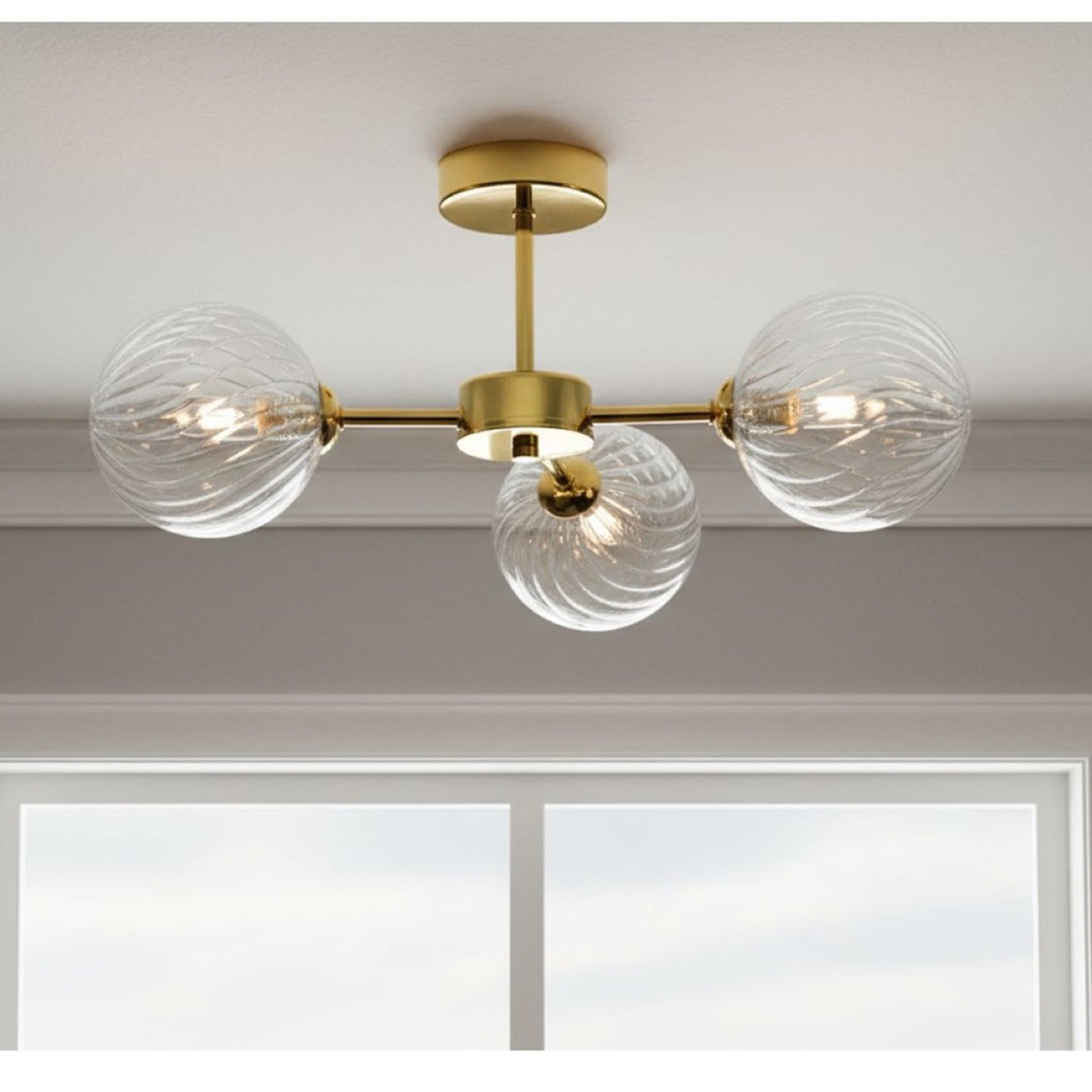 Ashby Swirled Glass 3 Light Semi-Flush Ceiling Light in brass, lit and fitted to a ceiling