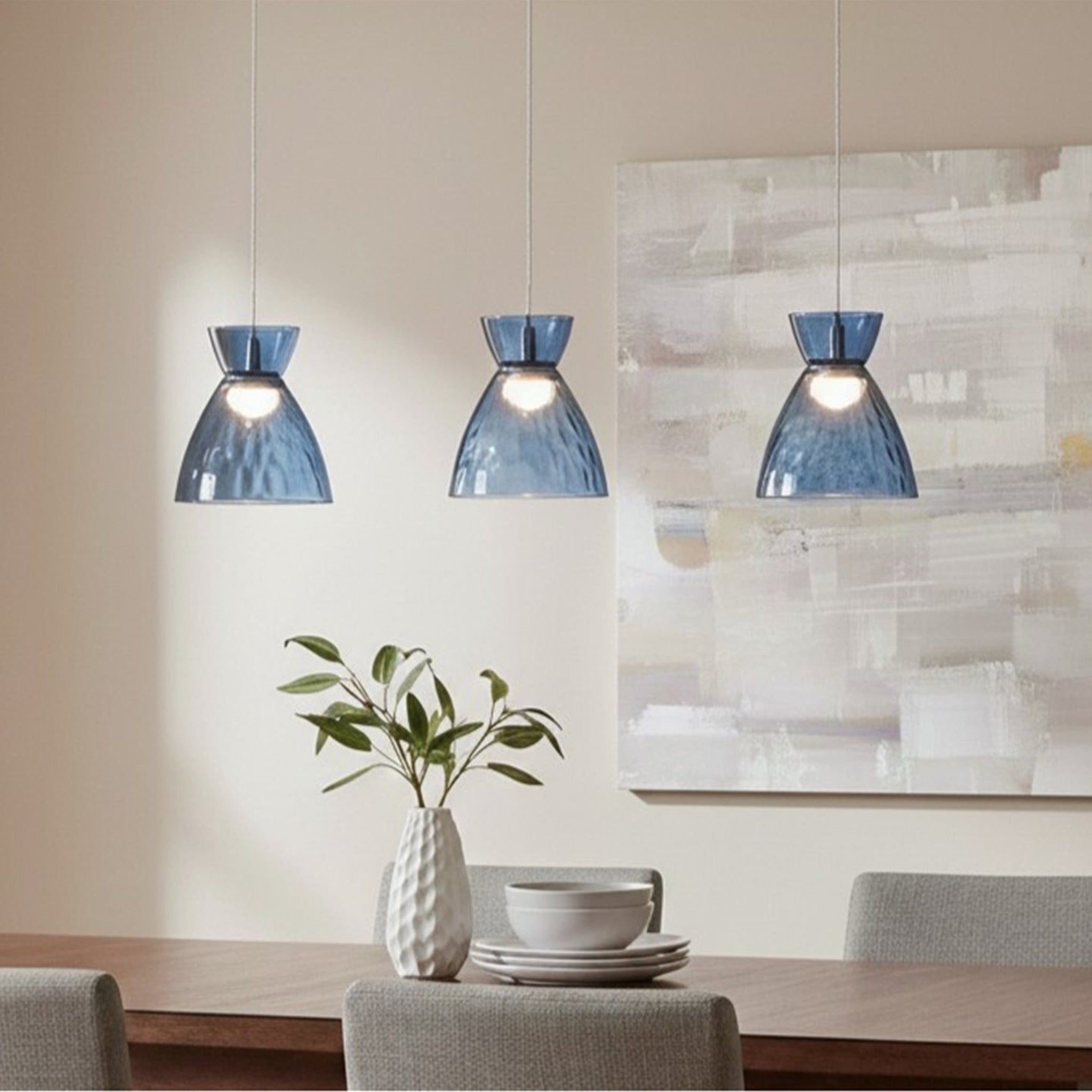 Bexley 3 Light Bar Pendant in blue glass hung over a dining table