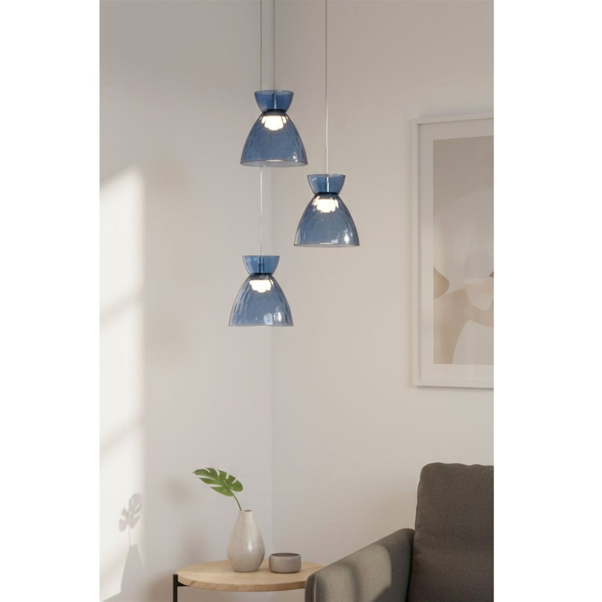 Bexley 3 Light Cluster Pendant in blue glass hung in a living room corner