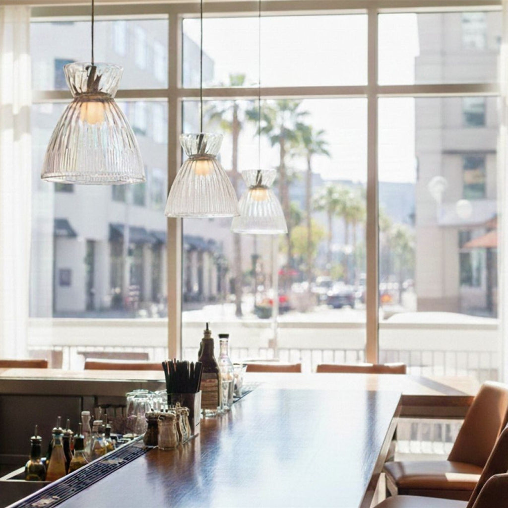 Bexley pendants in clear glass hung in a row over a bar counter