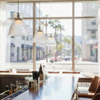 Bexley pendants in clear glass hung in a row over a bar counter
