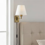 Blythe Swing Arm Plug-In Wall Light in bronze mounted beside a bed as a reading light