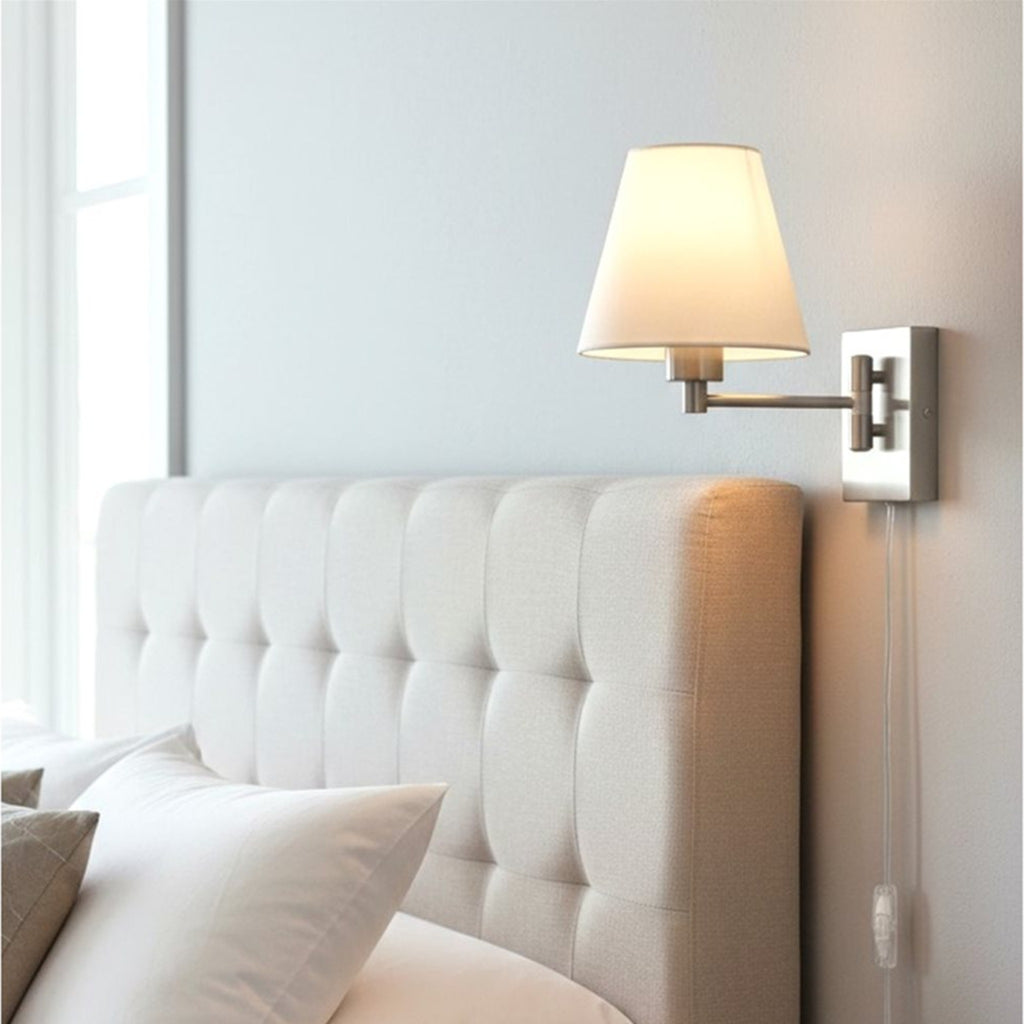 Blythe Swing Arm Plug-In Wall Light in brushed steel mounted above a bedside table