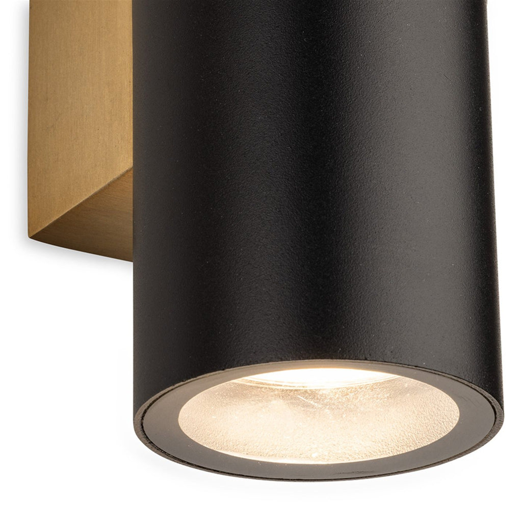Close-up detail of the Denby Slim Up & Down Wall Light in black, showing the lit lower cylinder
