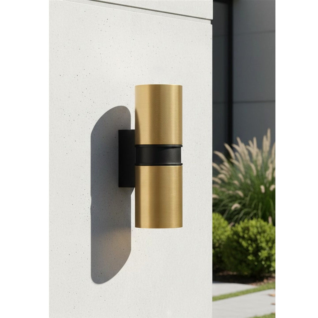 Denby Slim Up & Down Wall Light in brushed brass mounted on a rendered garden wall