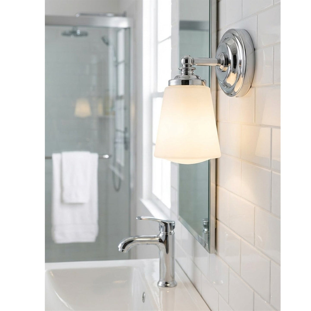 Hadley Opal Glass Bathroom Wall Light in chrome, lit beside a mirror above a bathroom basin