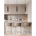 Black Kelso pendants hanging over a kitchen island with bar stools