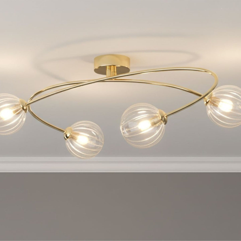 Linden Swirled Glass 4 Light Flush Ceiling Light in brass, lit on a living room ceiling