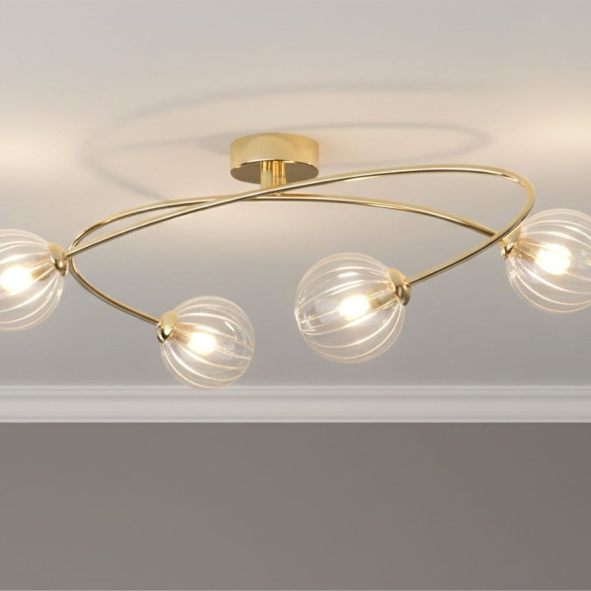 Linden Swirled Glass 4 Light Flush Ceiling Light in brass, lit on a living room ceiling