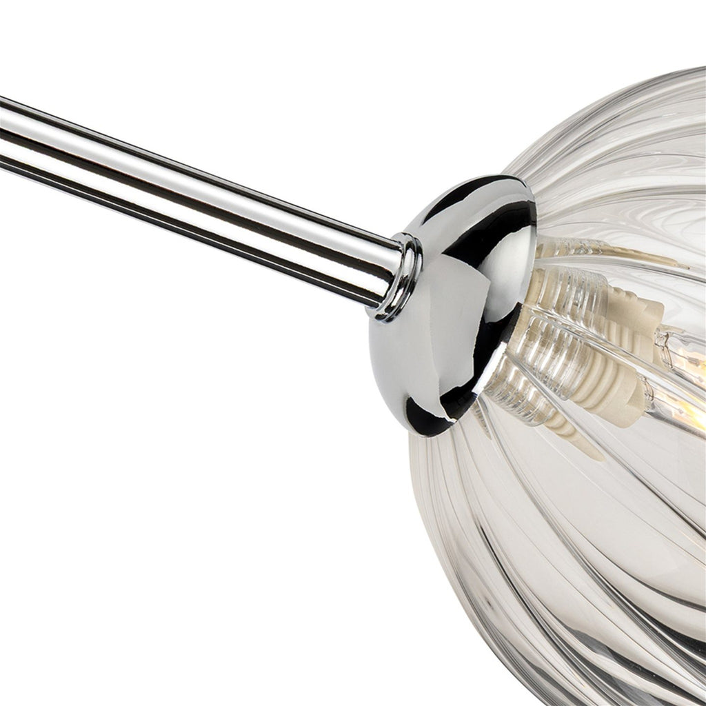 Close-up of the swirled clear glass globe and chrome fitting
