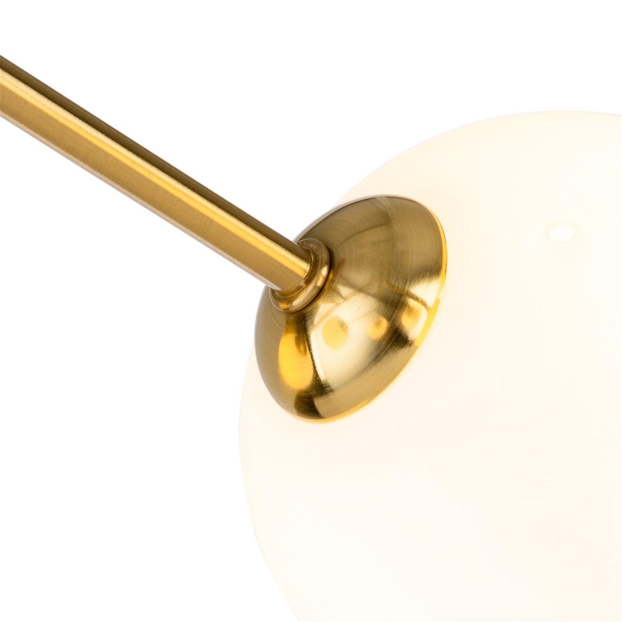 Close-up of an opal white glass globe on a brushed brass arm of the Lyra 6 Globe Flush Ceiling Light