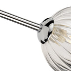 Close-up of a ribbed clear glass globe on a chrome arm of the Lyra 6 Globe Flush Ceiling Light