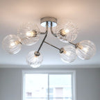 Lyra 6 Globe Flush Ceiling Light in chrome lit on a ceiling above a bright window