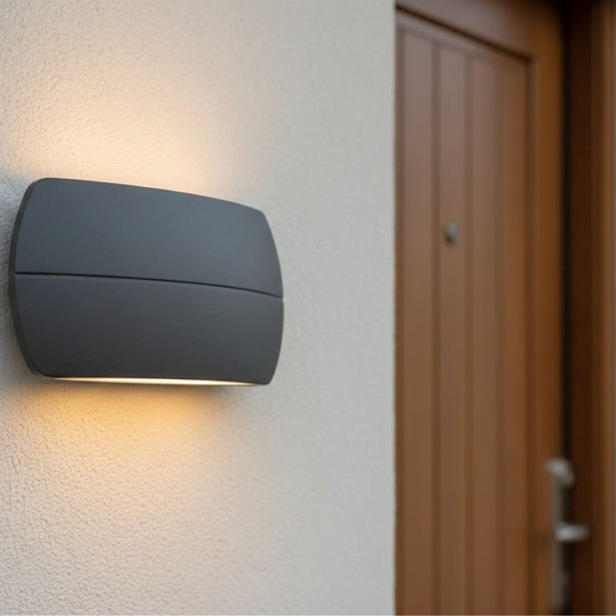 Nairn wall light in graphite lit beside a front door