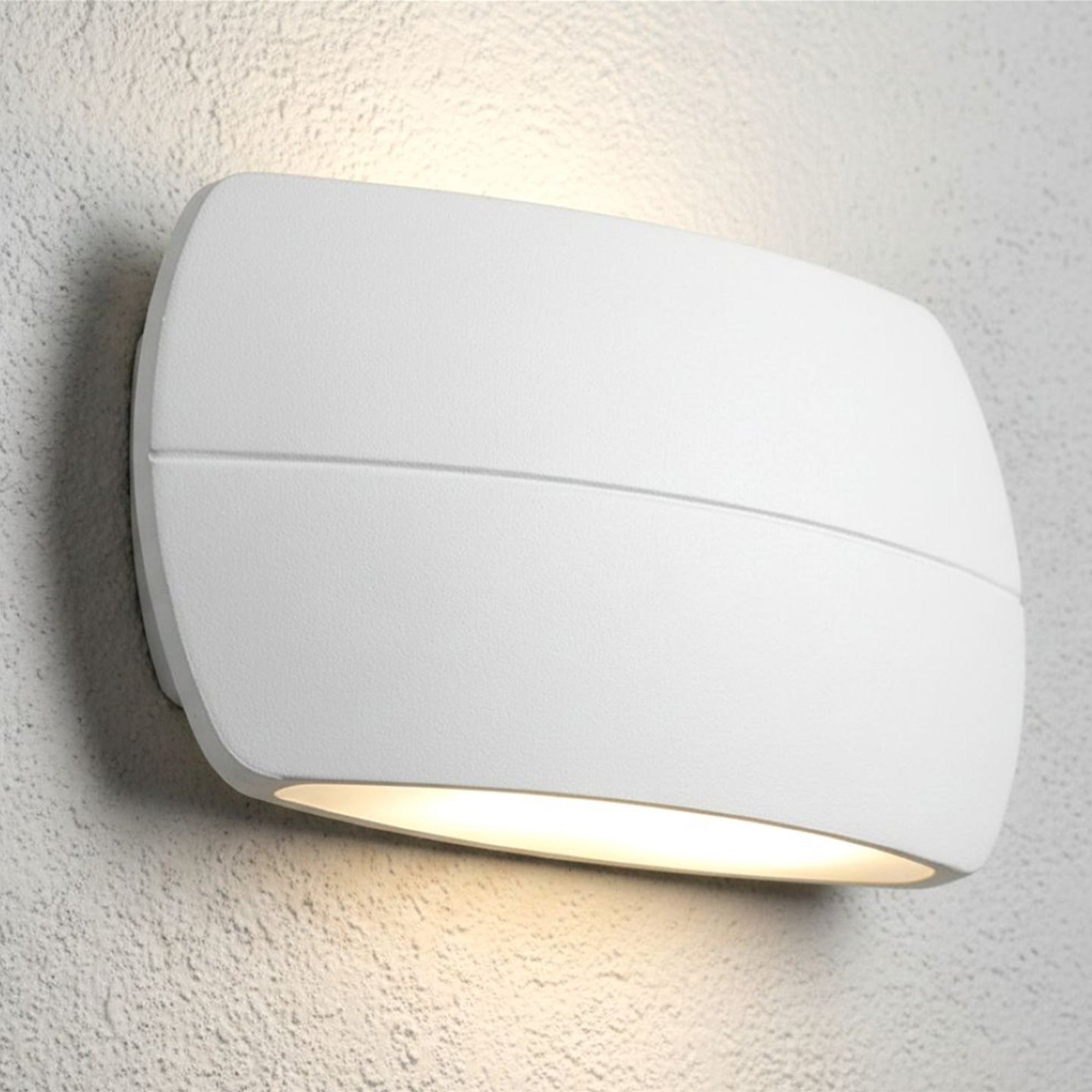 Nairn wall light in white lit on a textured exterior wall