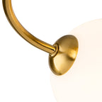 Close-up of a brushed brass arm meeting an opal white glass globe