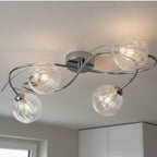 Orla Swirl Globe 4 Light Flush Ceiling Light in chrome lit on a room ceiling