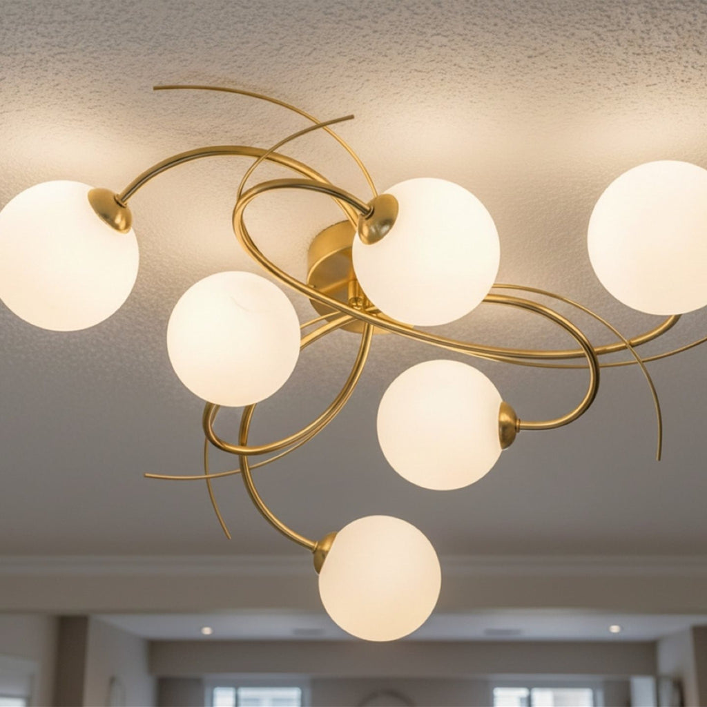 Orla Swirl Globe 6 Light Flush Ceiling Light in brushed brass lit on a room ceiling