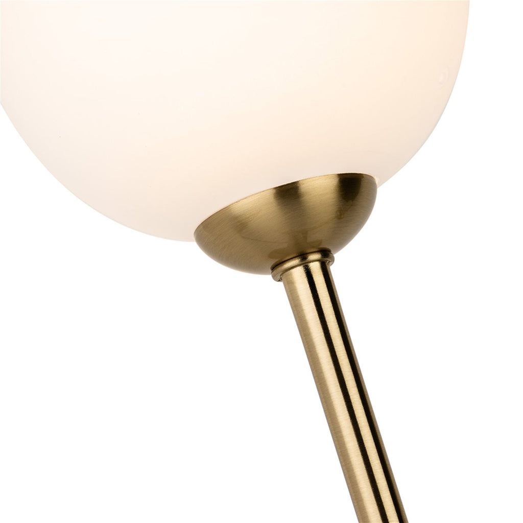 Close-up of an opal white glass globe on its brushed brass arm