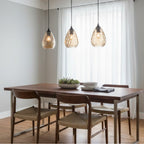 Three Orla Teardrop Glass Pendants in amber glass hanging in a row over a dining table