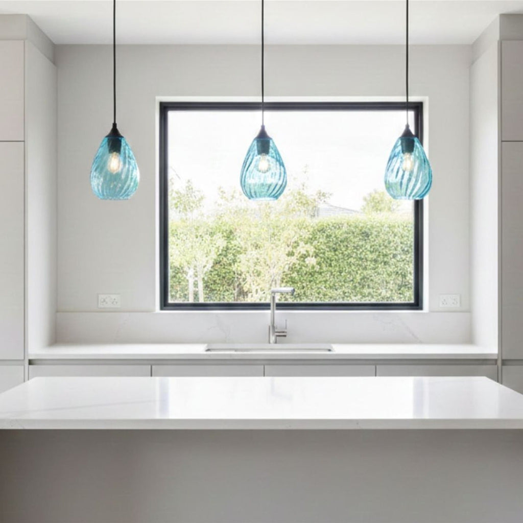 Three Orla Teardrop Glass Pendants in aqua glass hanging above a kitchen sink and window