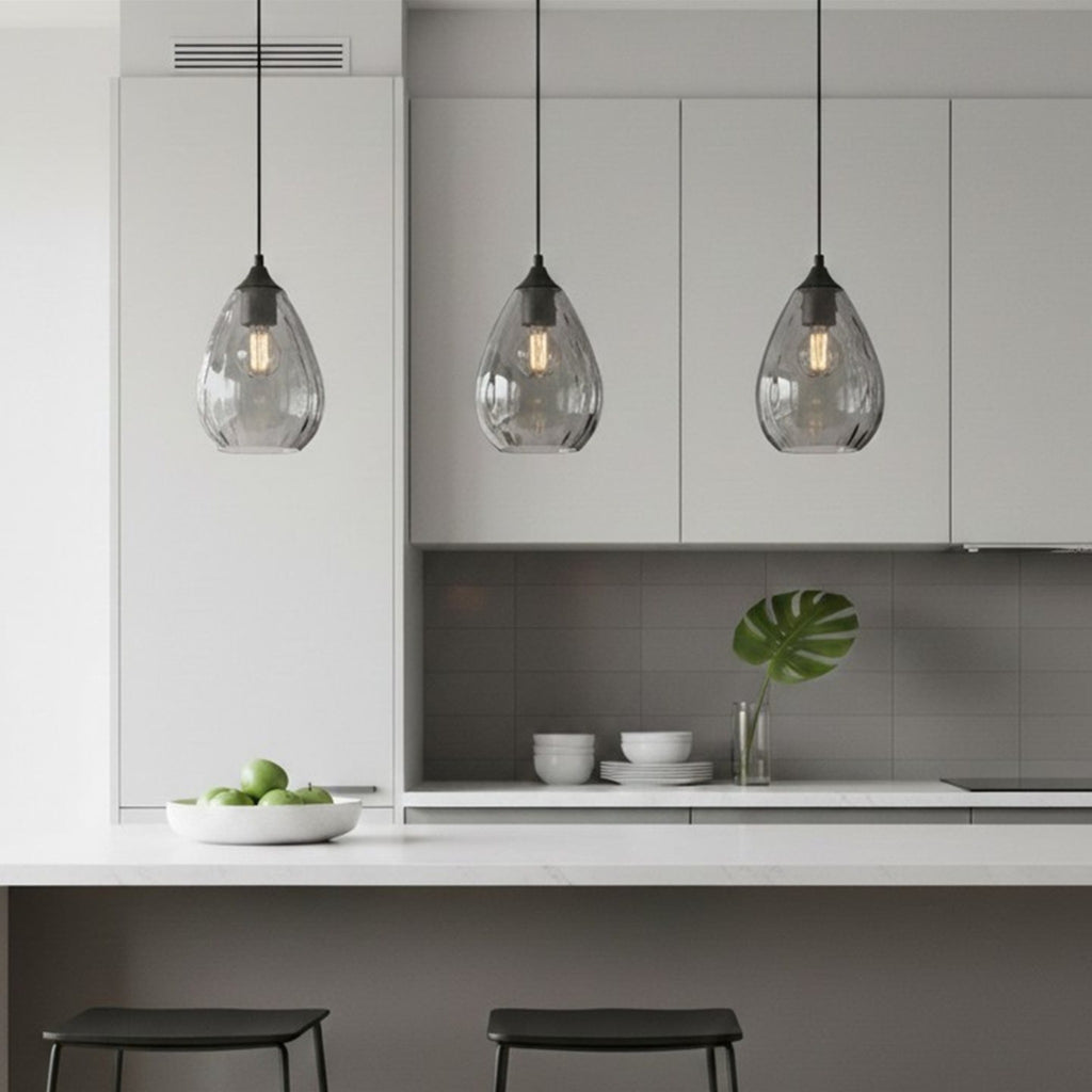 Three Orla Teardrop Glass Pendants in smoked glass hanging over a kitchen island