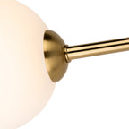Close-up of an opal white glass shade on its brushed brass arm