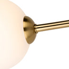 Close-up of an opal white glass shade on its brushed brass arm