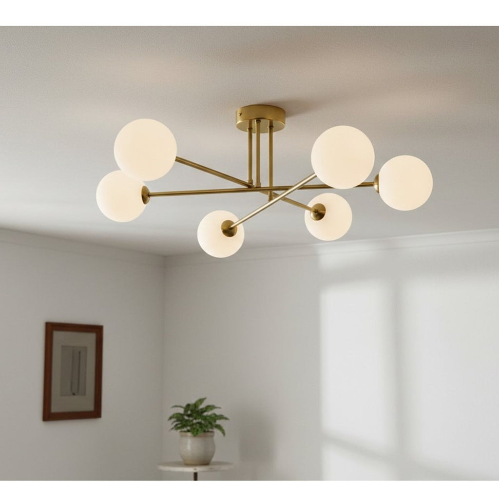 Ripley Glass Globe 6 Light Semi-Flush Ceiling Light in brushed brass, lit on a living room ceiling