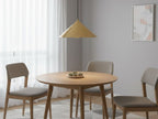 Rowan Conical Pendant in brushed brass hanging above a round wooden dining table
