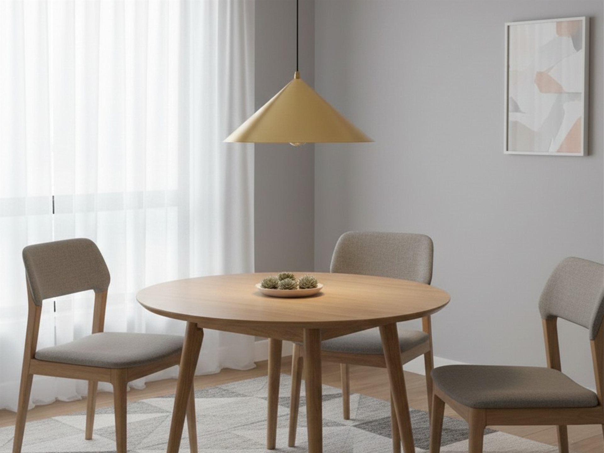 Rowan Conical Pendant in brushed brass hanging above a round wooden dining table