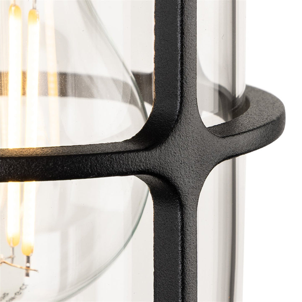 Close-up of the textured black cage and clear glass on the Tarbet Caged Glass Outdoor Wall Light