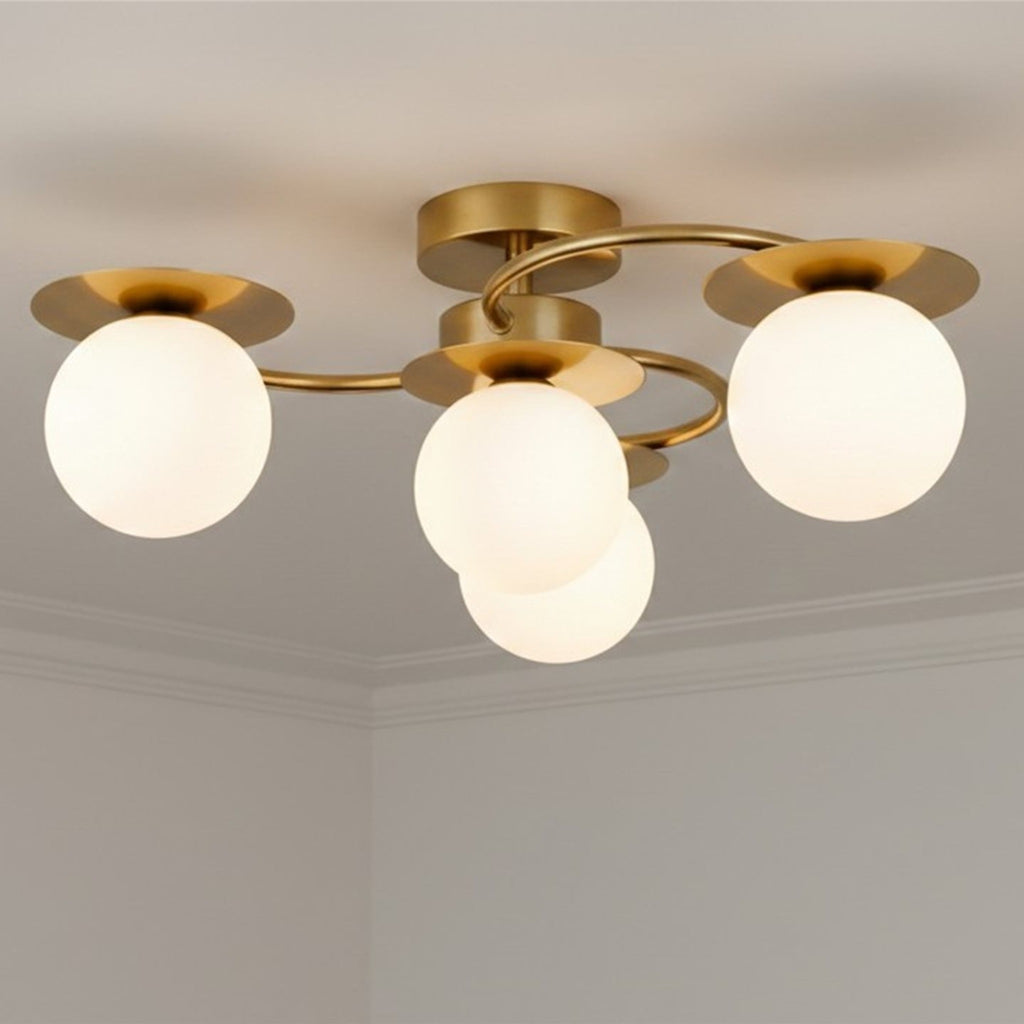 Thea 4 Light Opal Globe Flush Ceiling Light in brushed brass fitted to a living room ceiling